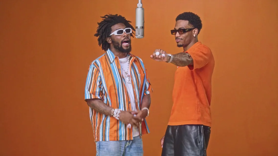 Hotel Lobby reference frame showing two performers exchanging gestures under a microphone